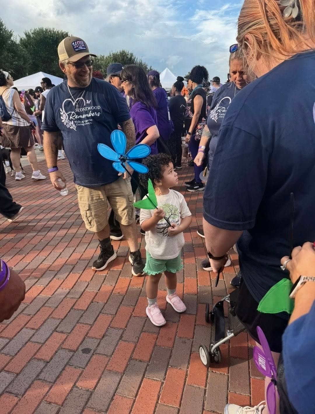 Child holding a pinwheel at the Walk to End Alzheimer’s with Stonewood team