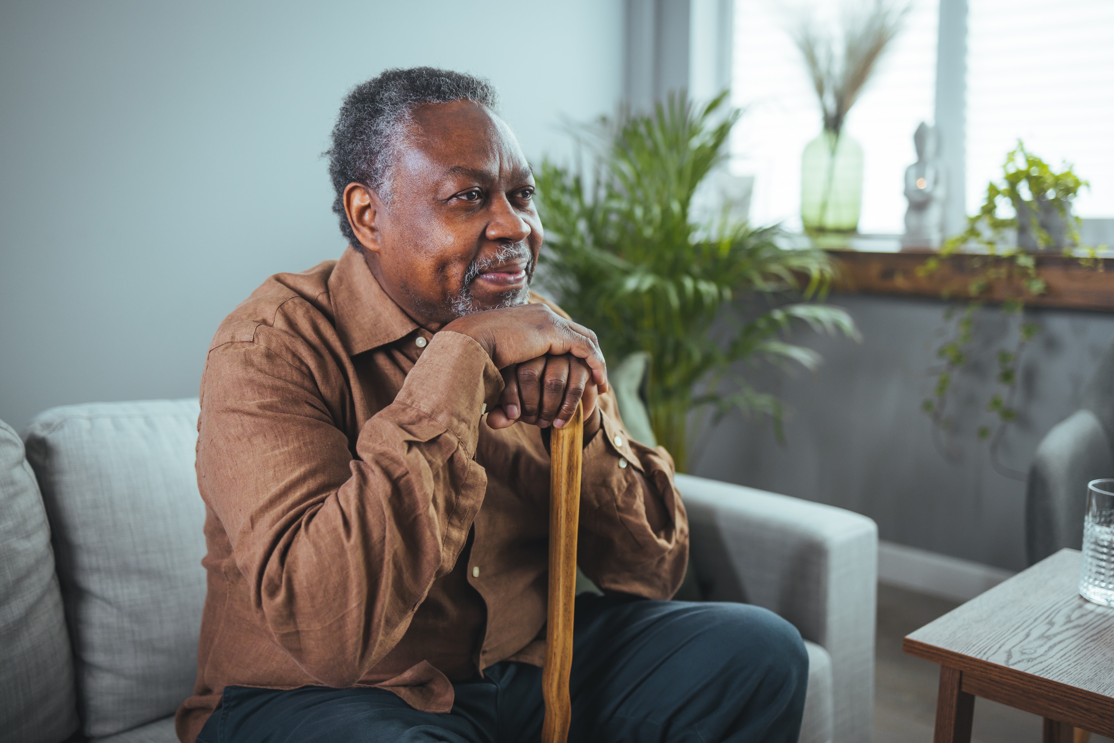 Senior man sitting thoughtfully at home, reflecting on care options